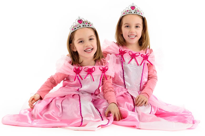 Two little girls dressed in pink princess outfits.
